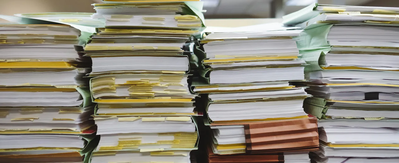 Stacks of academic documents and file folders for study abroad applications