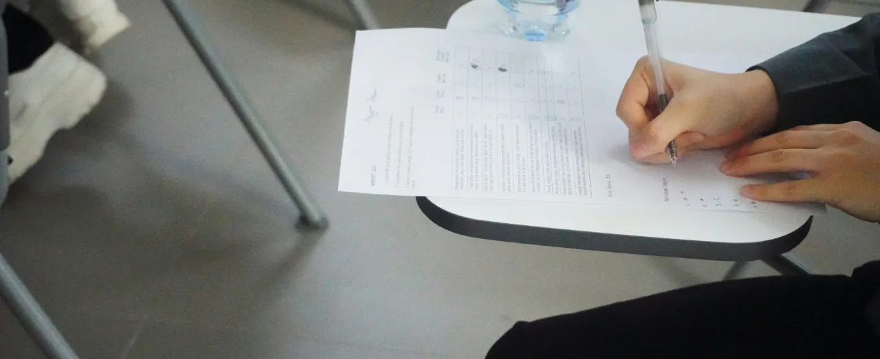 Student filling in a test answer sheet during an SAT or ACT exam