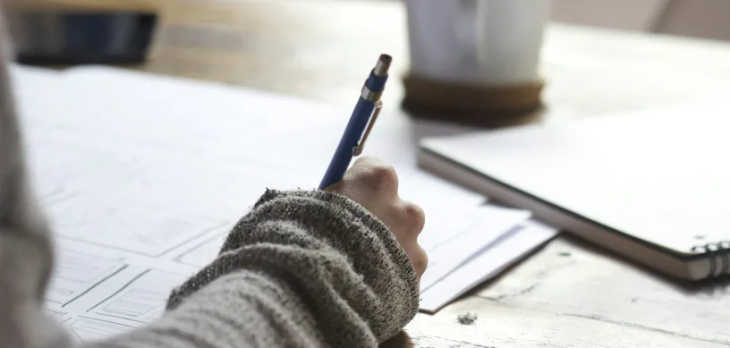 Student writing notes while preparing for the SAT or ACT
